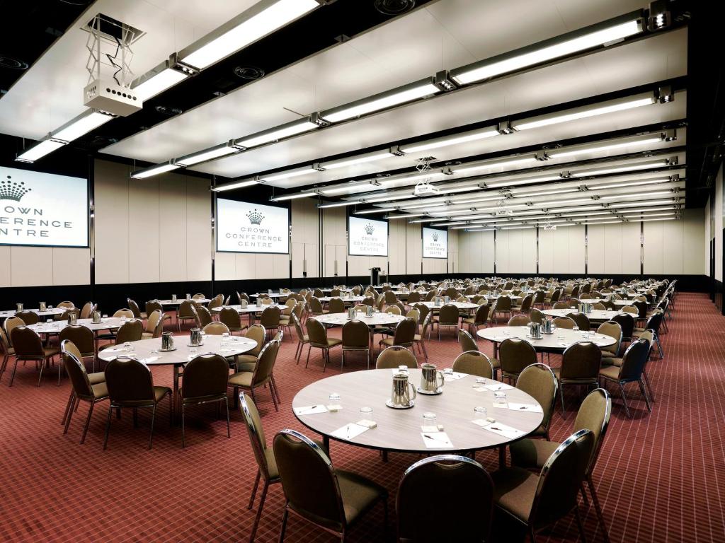 a large room with tables and chairs in it at Crown Promenade Melbourne in Melbourne