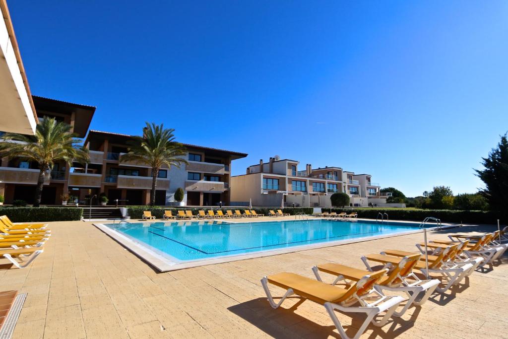 a swimming pool with lounge chairs and a resort at Monte Laguna - Clever Details in Vilamoura
