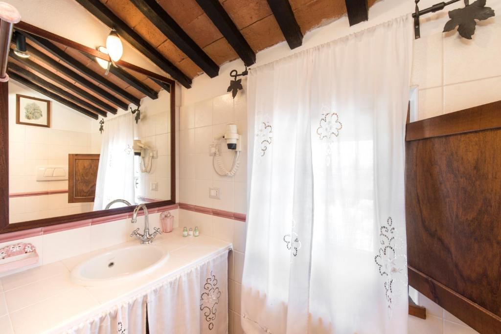 a bathroom with a sink and a shower curtain at Borgo Tre Rose in Valiano