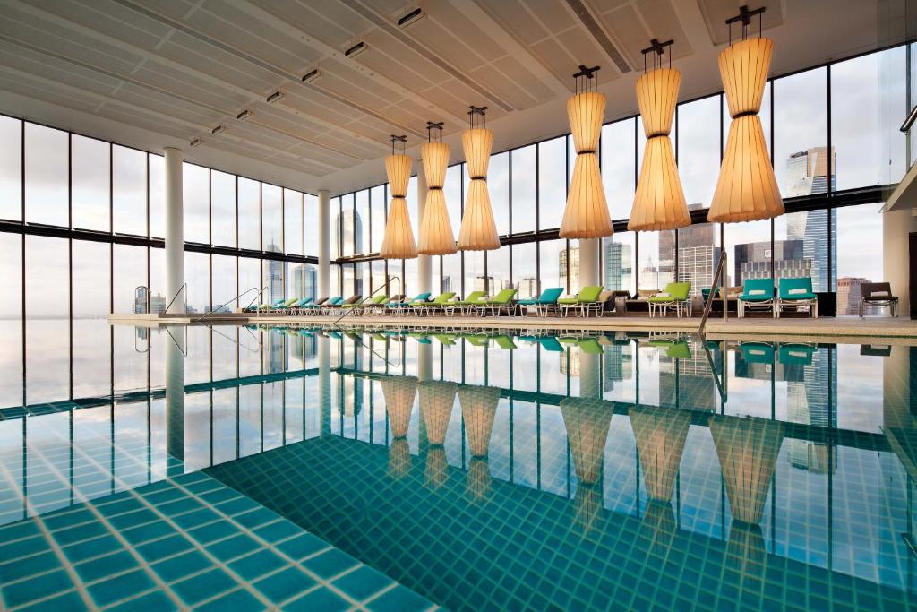 a swimming pool in a building with windows at Crown Metropol Melbourne in Melbourne