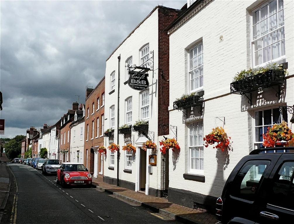 una fila de edificios blancos en una calle con coches en The Croft, en Bridgnorth