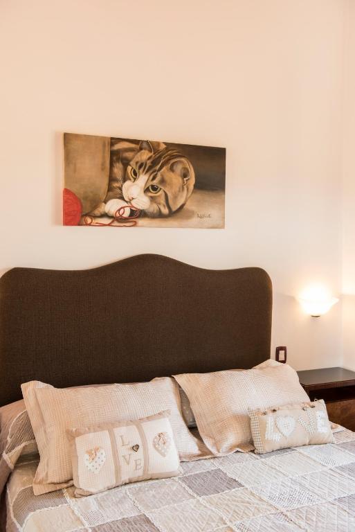 a picture of a cat on the wall above a bed at Borgo Tre Rose in Valiano