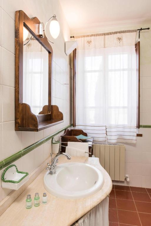 a bathroom with a sink and a mirror at Borgo Tre Rose in Valiano