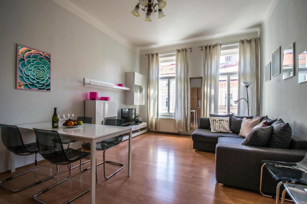sala de estar con mesa y sofá en Modern Cozy Apartment by Ruterra, en Praga