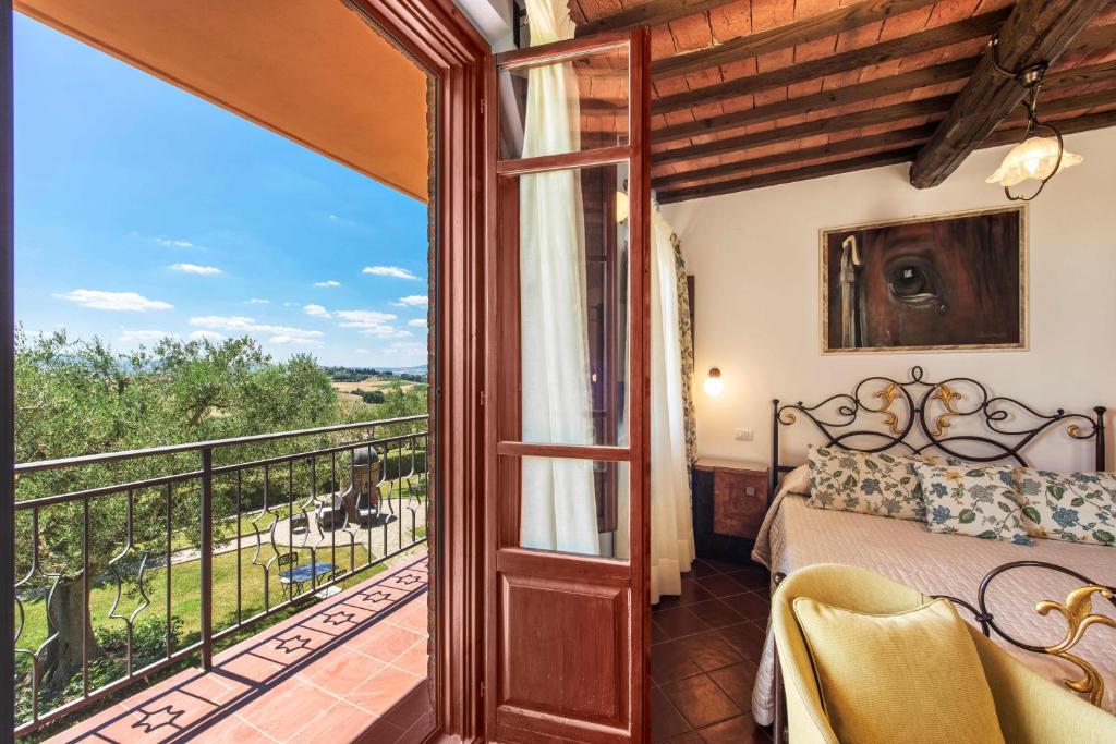 a bedroom with a bed and a balcony at Borgo Tre Rose in Valiano