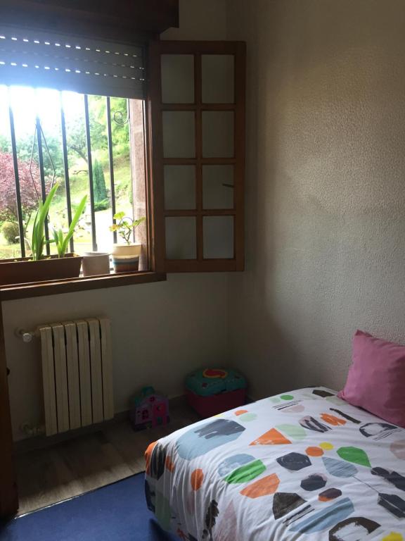 a bedroom with a bed and a window with at CASA EL CASTAÑÉU in Arriondas