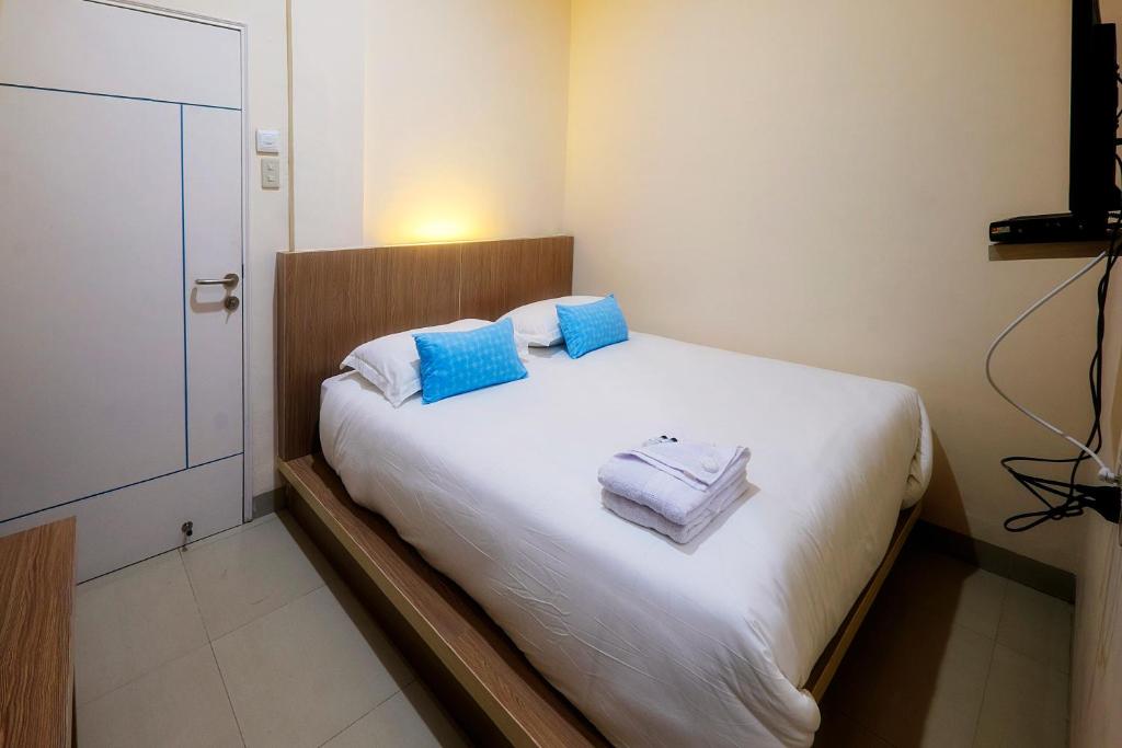 Arya Inn في بيماتانغسياتار: غرفة نوم عليها سرير وفوط زرقاء