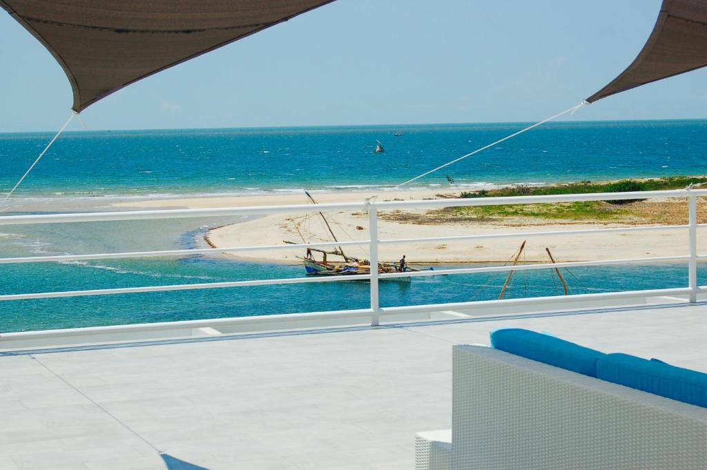 un balcón con vistas a la playa y al océano. en PAP'S Chambres d'Hôtes en Mahajanga