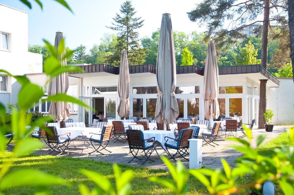 een groep tafels en stoelen met parasols bij Parkhotel Styria in Steyr