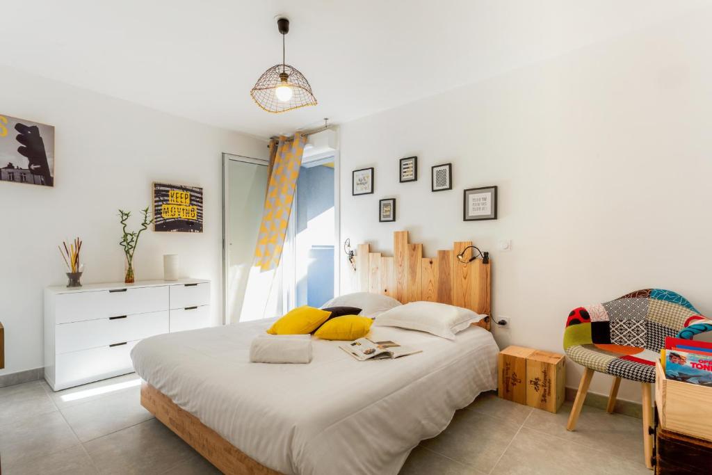 a bedroom with a large bed with yellow pillows at Luminescence Parc Marianne - Première conciergerie in Montpellier