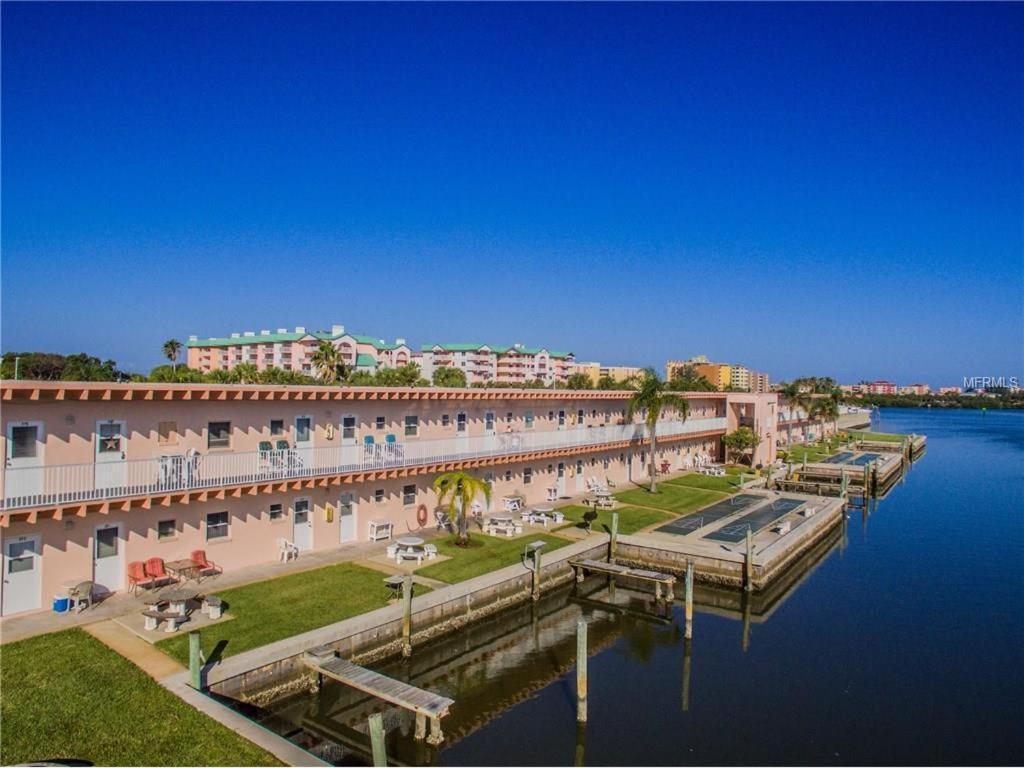 a building with a dock next to a body of water at Belleview Gulf Condos in Clearwater Beach