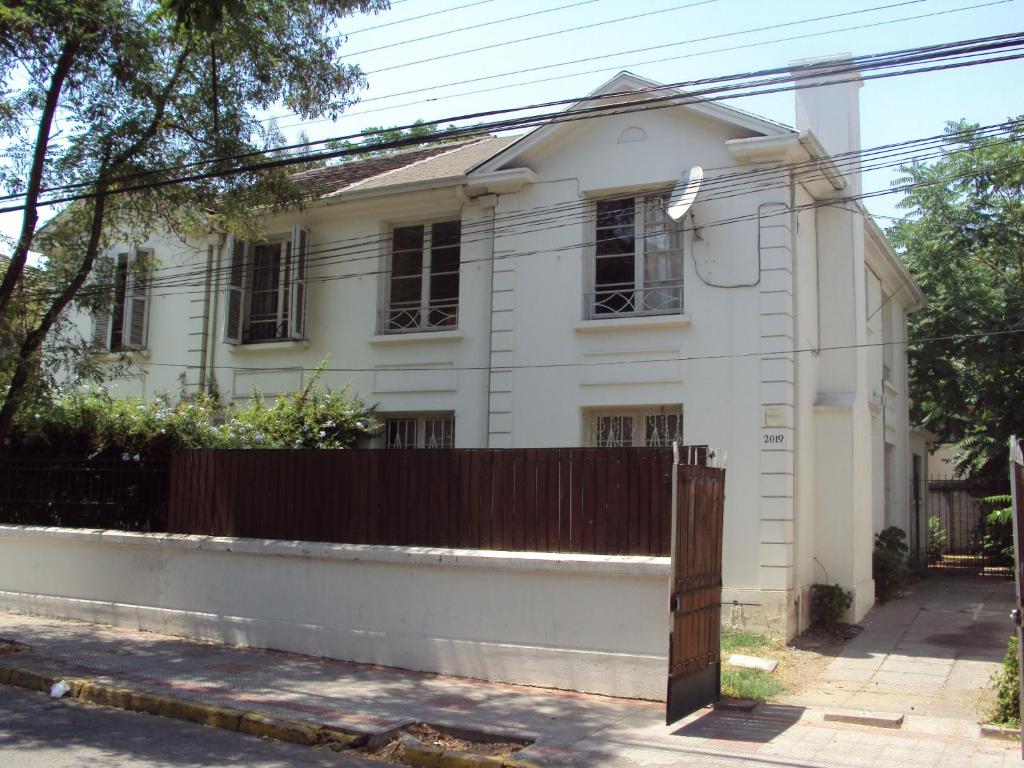 una casa blanca con una valla delante en Casa Familiar en Santiago