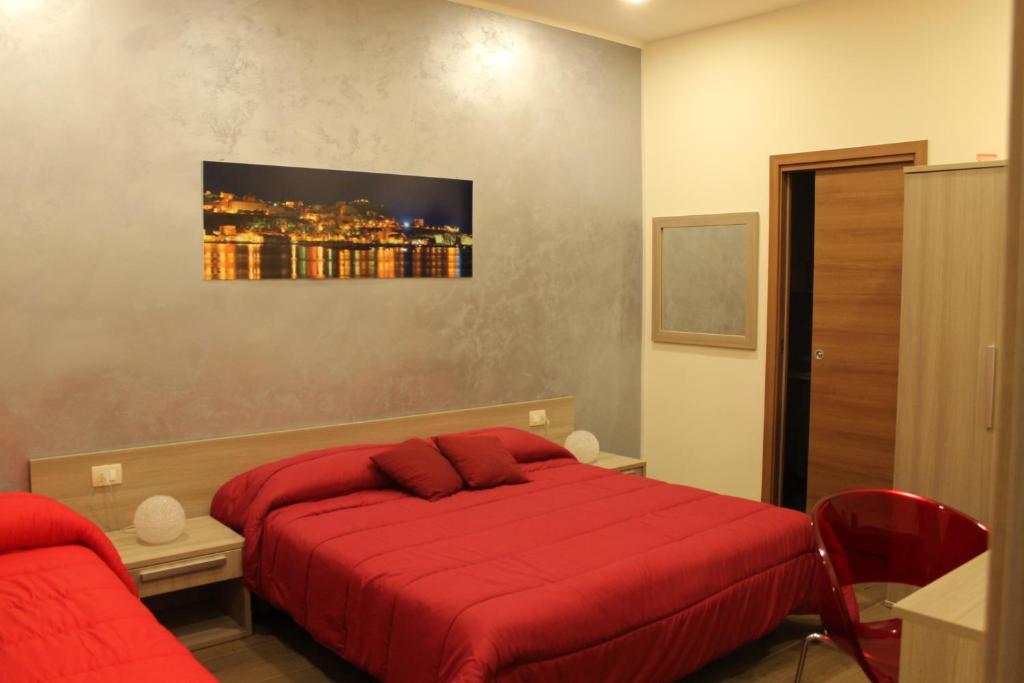 シャッカにあるPorta Palermo B&Bのベッドルーム1室(赤いベッド1台、赤い椅子付)