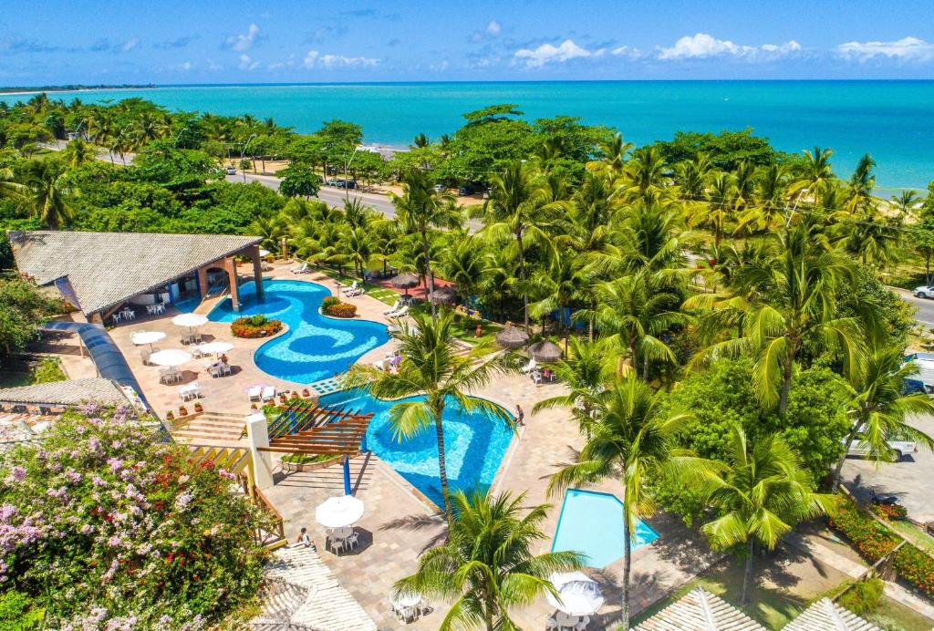 uma vista aérea de um resort com piscina e oceano em Portobello Praia em Porto Seguro