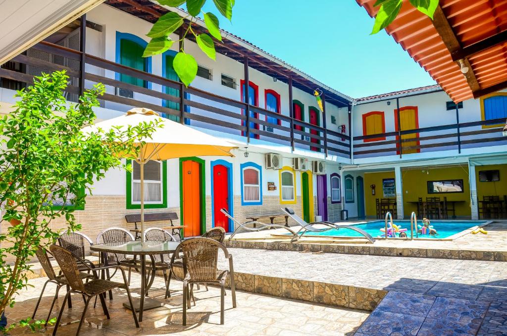 un patio con mesa y sillas junto a una piscina en Pousada Primavera, en Paraty