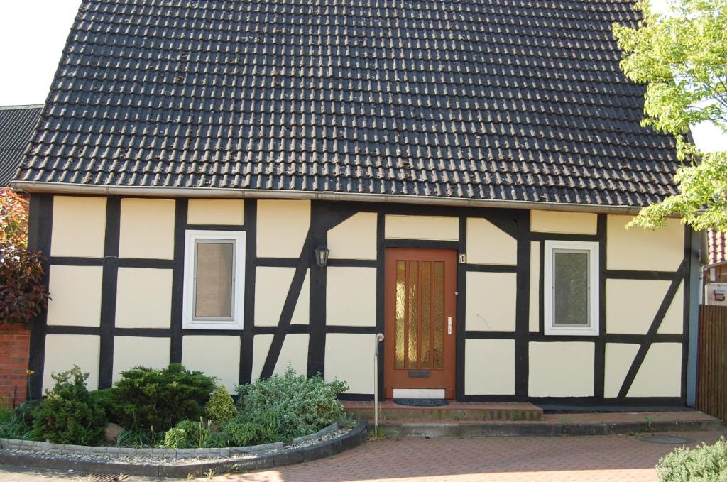 una casa en blanco y negro con una puerta marrón en Ferienhaus Stollenwerk am Steinhuder Meer - Wunstorf OT Steinhude, Achternümme en Steinhude