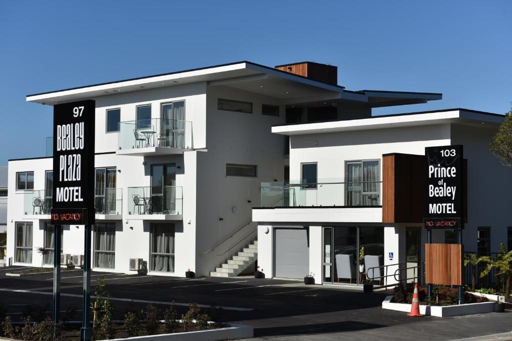 un edificio blanco con un cartel delante en 103 Prince of Bealey Motel, en Christchurch