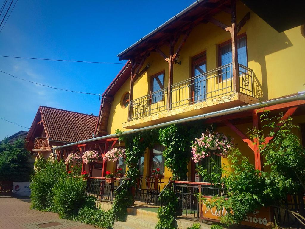 un edificio amarillo con balcones y flores. en Villa Negra Motel en Berzence