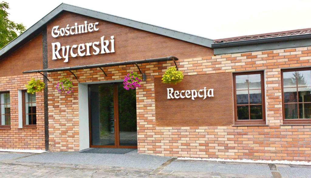 a brick building with flowers on the front of it at Gościniec Rycerski in Malbork