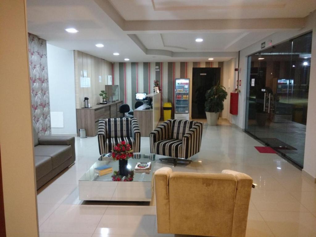 a lobby with chairs and a table in a building at Conquista Palace Hotel in Vitória da Conquista