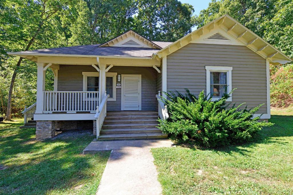 a small house with a porch and stairs to it at Kentucky Dam Village State Resort Park in Gilbertsville