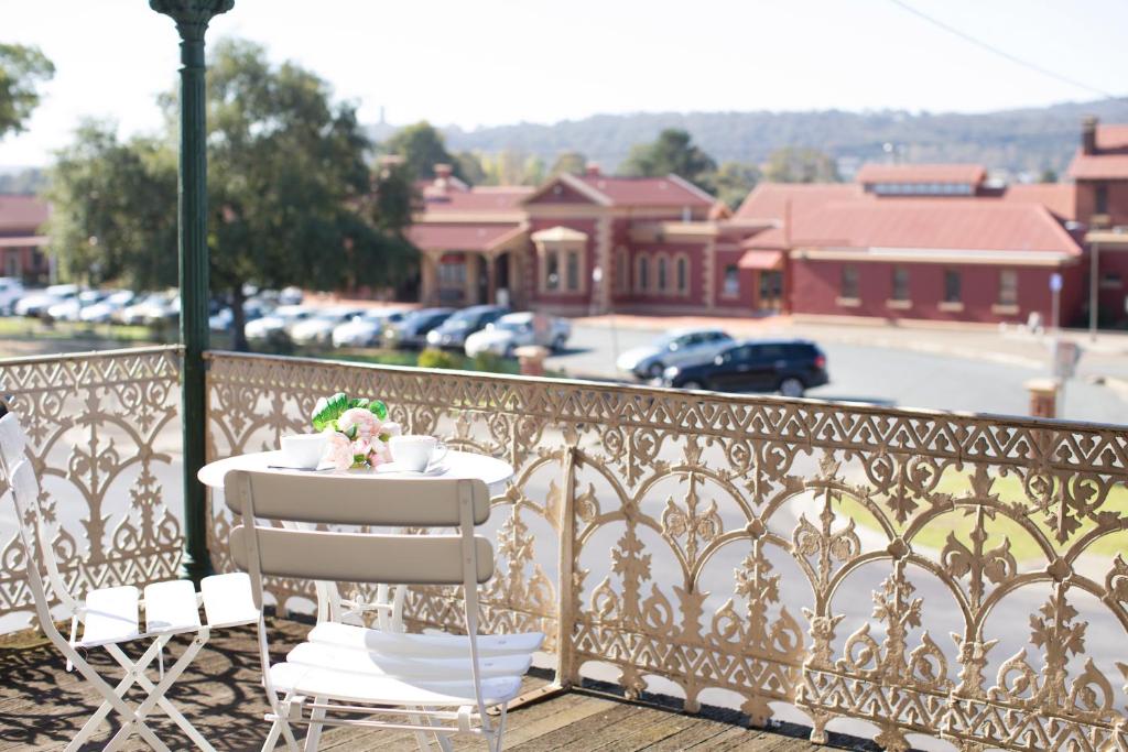 a table and chairs on a balcony with a view at Southern Railway Hotel Goulburn in Goulburn