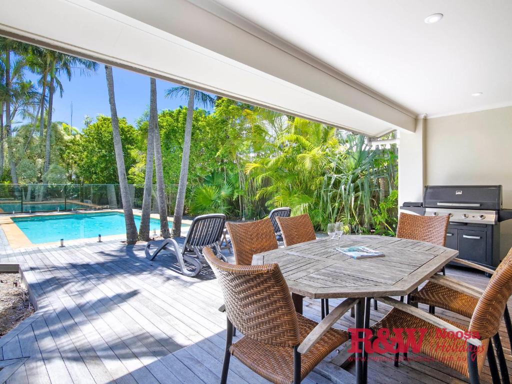 a dining room with a table and chairs and a pool at 14 Witta Circle, Noosa Heads in Noosa Heads