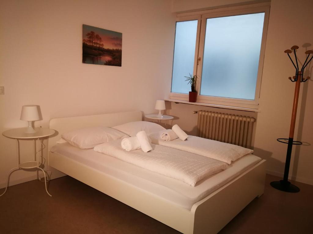 a white bed with two stuffed animals on it at Central Rooms in Bolzano