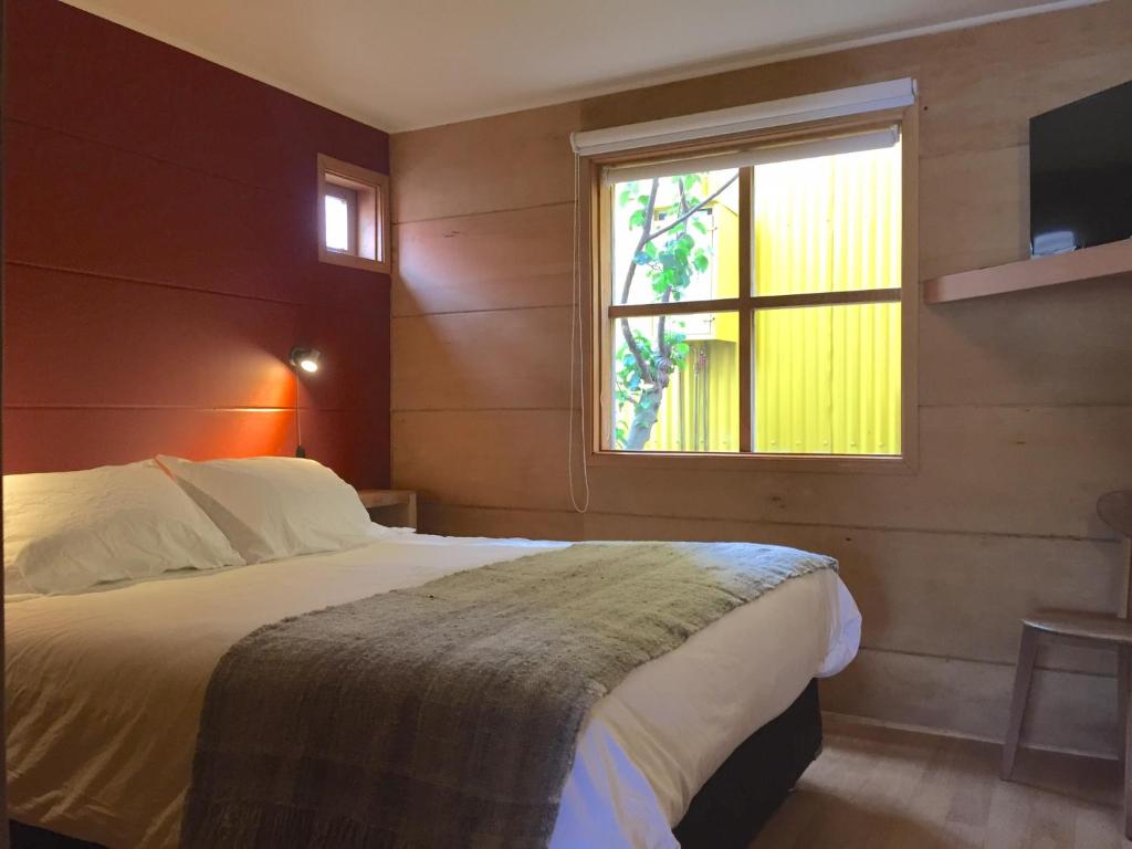 a bedroom with a bed and a window at Palafito Azul Apart Hotel in Castro