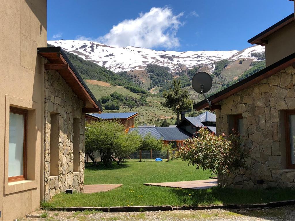 uma vista para uma montanha coberta de neve entre dois edifícios em Complejo Mil50 em San Carlos de Bariloche