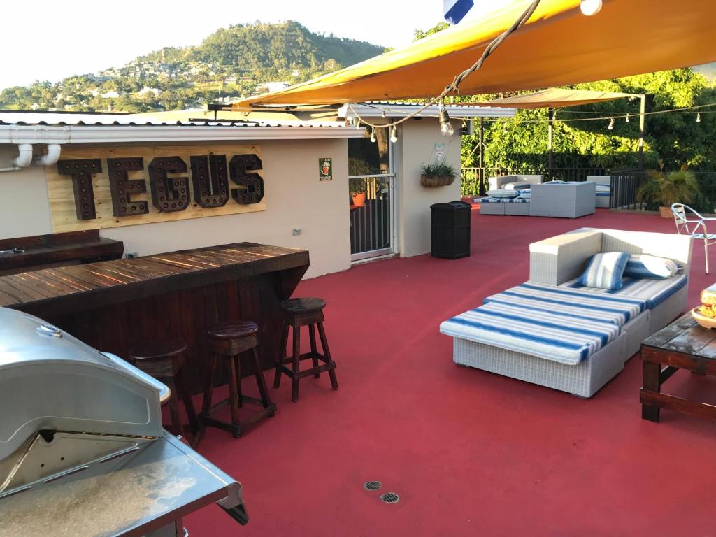 a patio with a bar with a couch and a piano at Palmira Hostel in Tegucigalpa