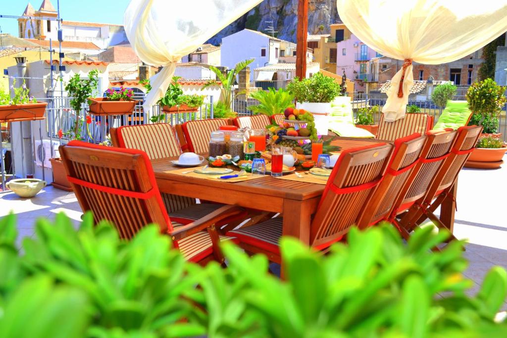 a wooden table and chairs on a patio at Scirocco in Cefal&ugrave;