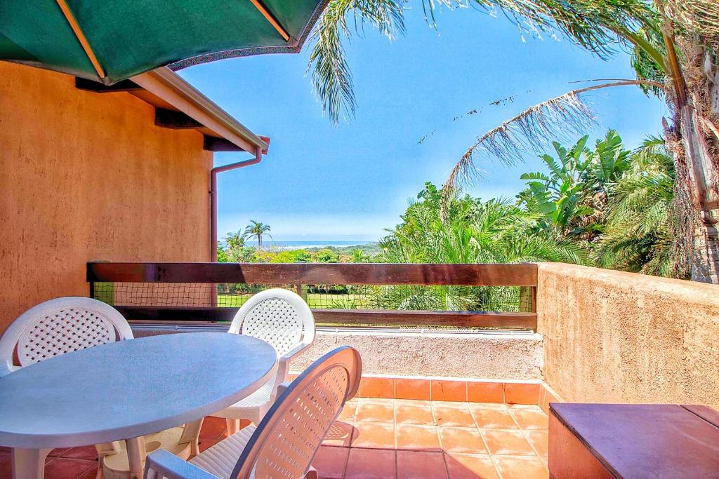 a table and chairs on a balcony with a view of the ocean at Lot 25 SM06 in Southbroom