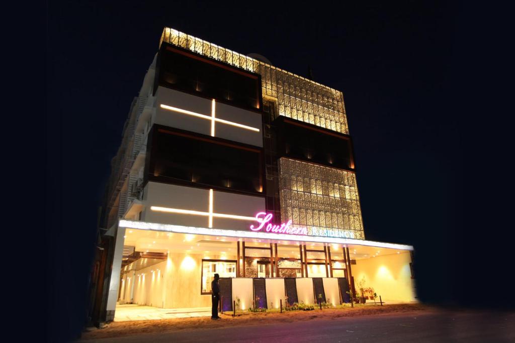 un edificio con un cartel de neón en él por la noche en Hotel Southern Residency en Kelambākkam
