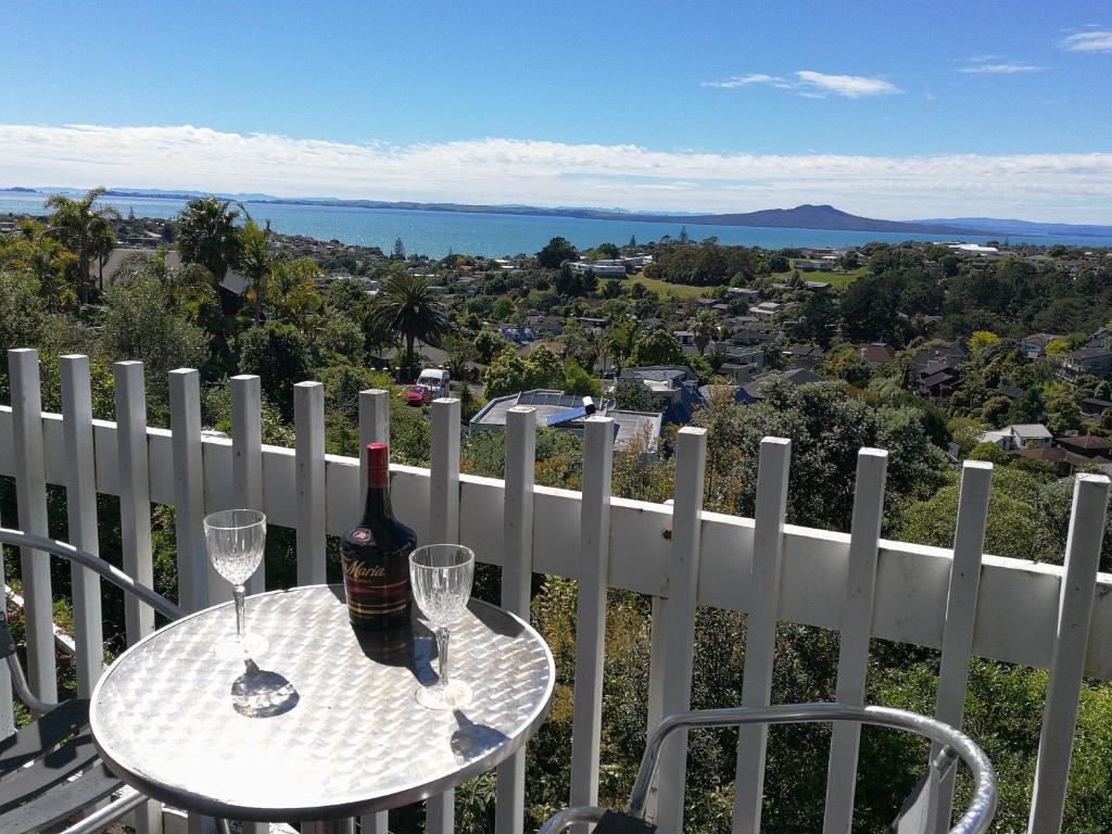 a table with a bottle of wine and two wine glasses at Harbour View Guesthouse in Auckland