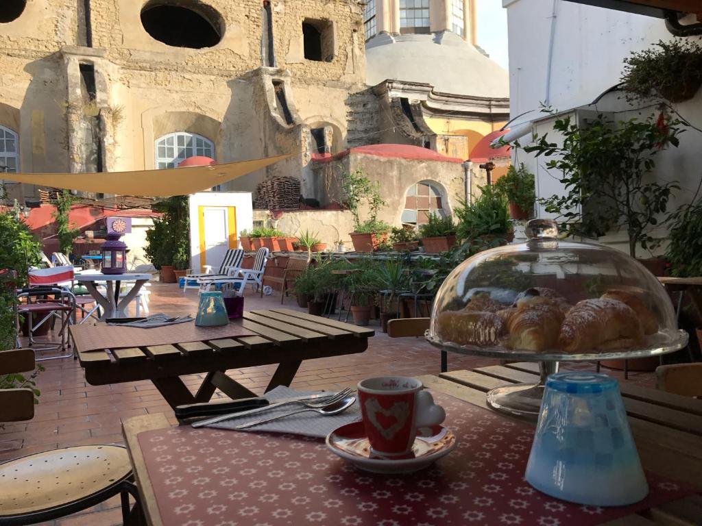 einen Tisch mit einem Tablett mit Gebäck und einer Tasse Kaffee in der Unterkunft B&B La Terrazza Napoli in Neapel