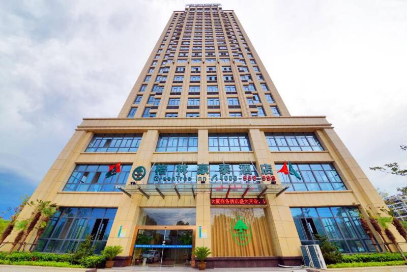 HelixiにあるGreenTree Inn AnHui Ningguo Ningguo Avenue Business Hotelの表札のある高層ビル