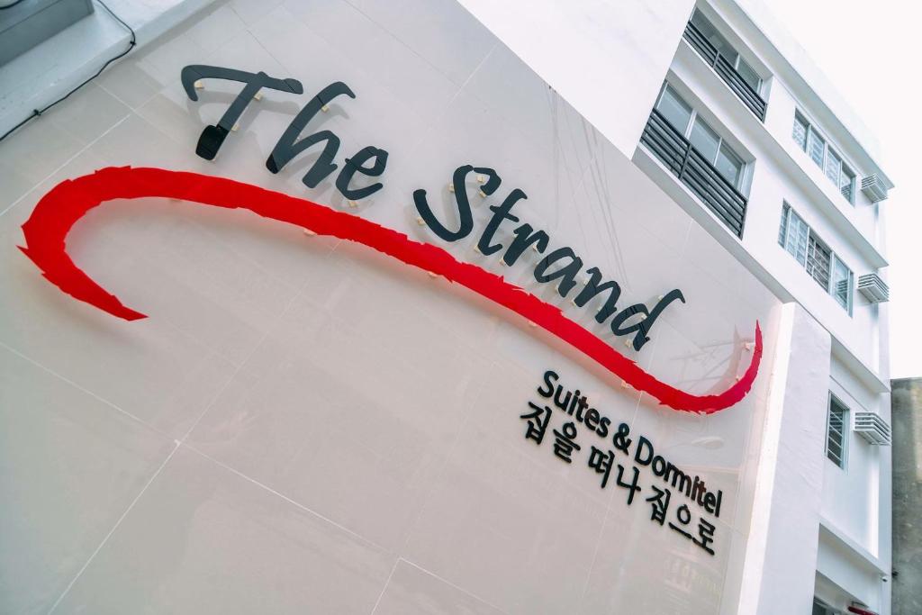 The Strand Suites and Dormitel في مدينة دافاو: علامة على جانب مبنى به شفاه حمراء