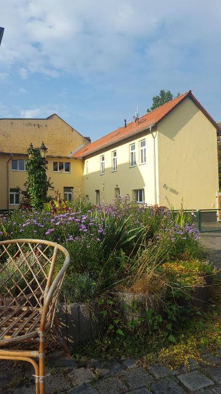 eine Bank vor einem Gebäude mit lila Blumen in der Unterkunft Fewo an der Bode in Quedlinburg