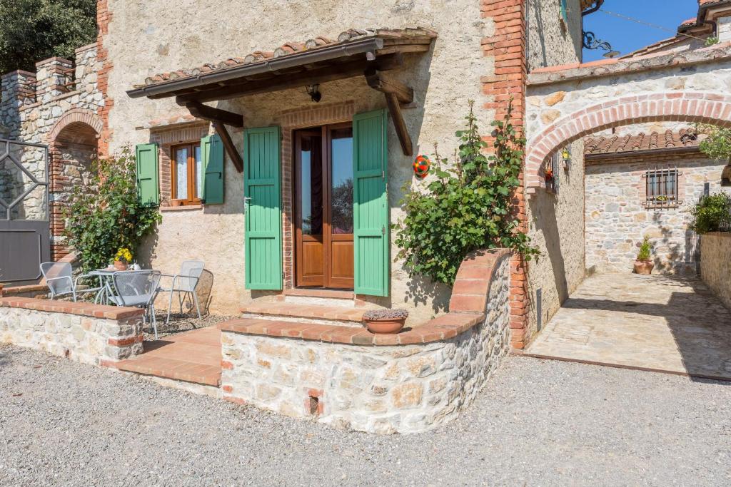 ein Haus mit einer grünen Tür und einer Terrasse in der Unterkunft Agriturismo Borghetto Il Montino in Rapolano Terme