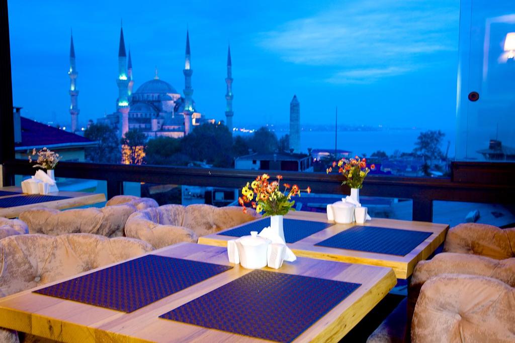 uma varanda com mesas e cadeiras e vista para uma mesquita em Hotel Perula em Istambul