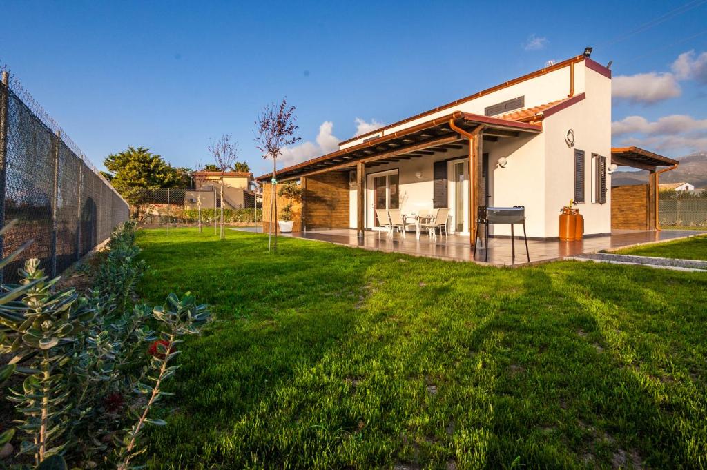 ein Haus mit grünem Rasen davor in der Unterkunft Villa Barbara...a 100 passi dal mare!!!! in Lascari