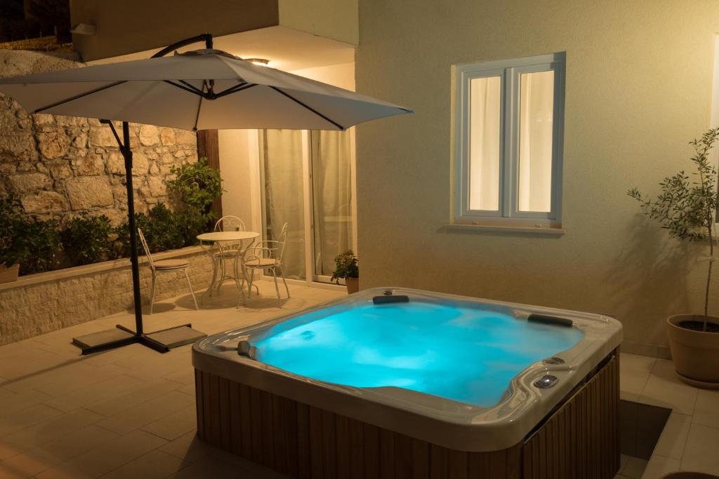 a jacuzzi tub in a room with an umbrella at Dida moj in Senj