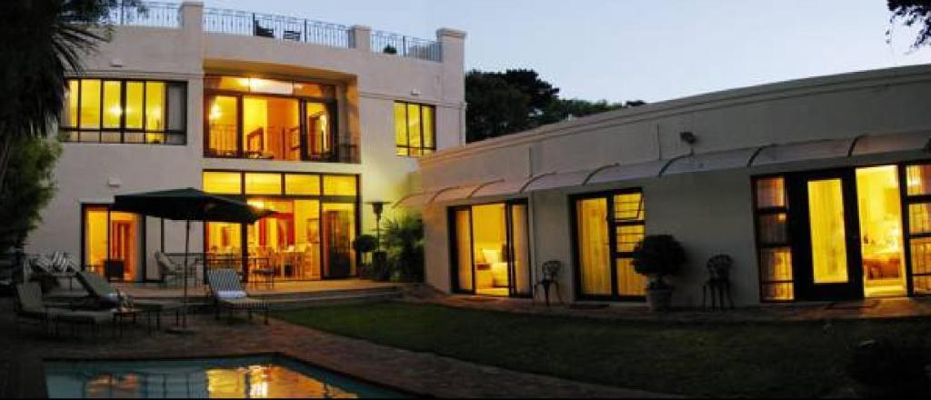 una casa grande con piscina frente a ella en Riversong Guest House, en Ciudad del Cabo