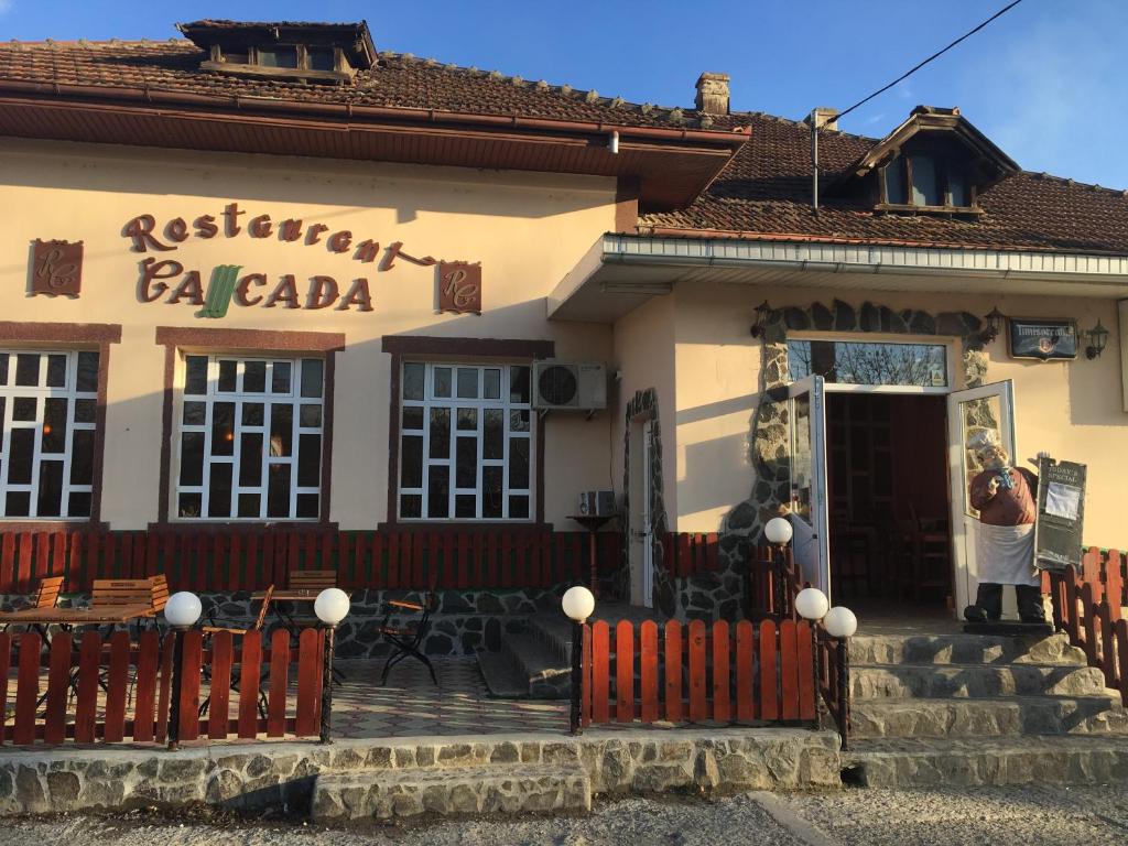 a person standing in front of a building at Pensiunea Cascada in Comăneşti