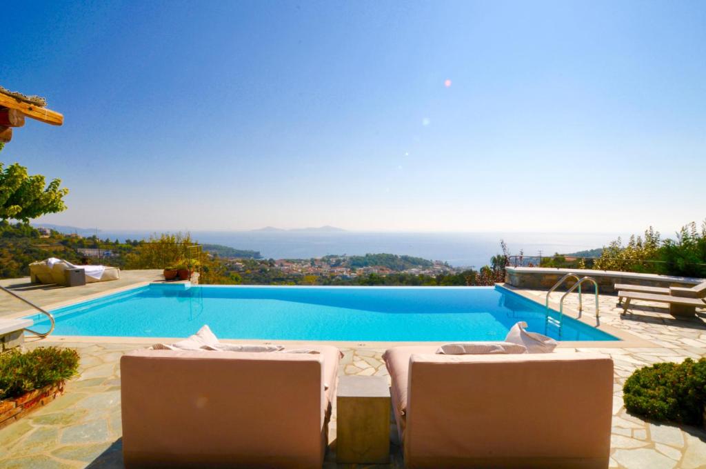 a swimming pool with two tables and two chairs at Villa Paparouna in Patitiri