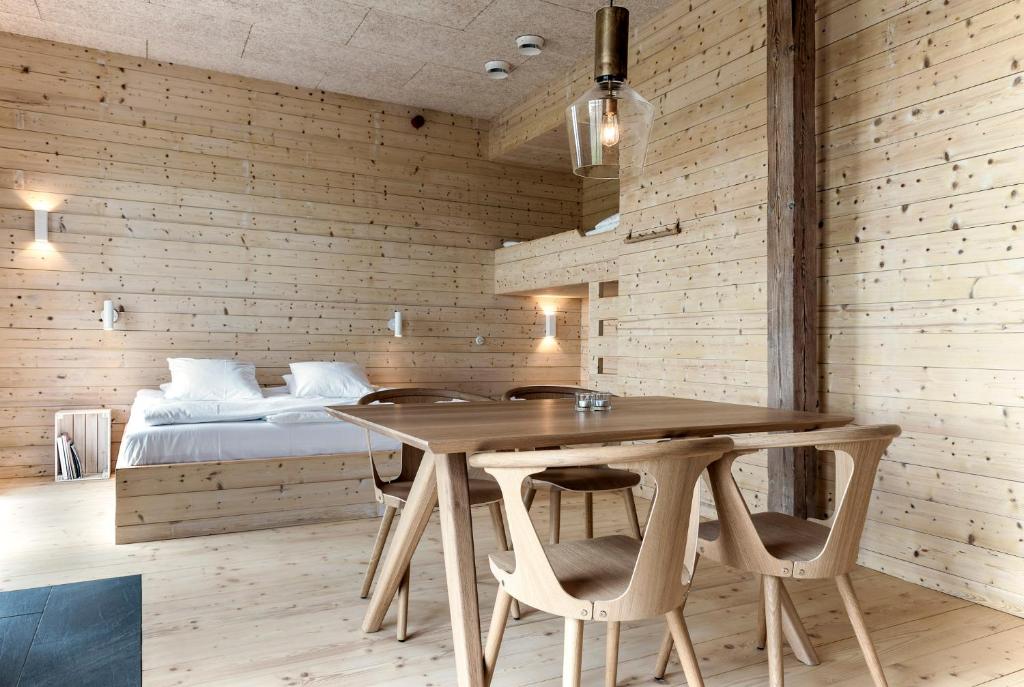 Lindeborgs Eco Retreat في Vrena: غرفة خشبية مع طاولة وسرير