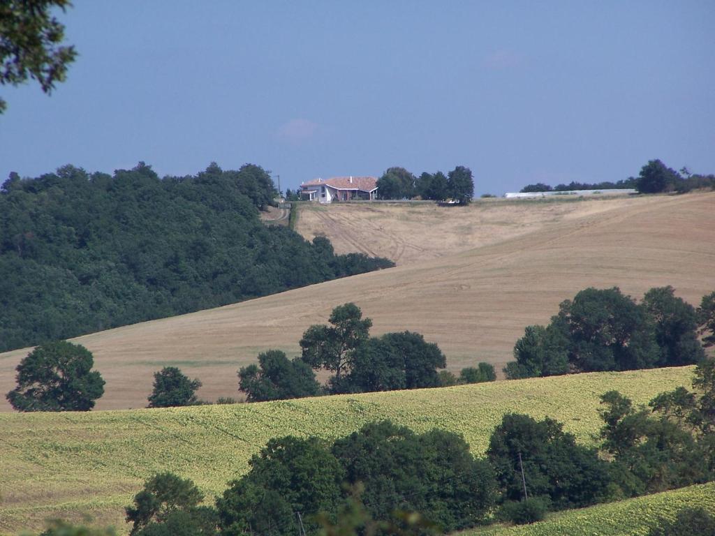 a field with trees and a house on a hill at Villa Le Rabailly in Mérenvielle