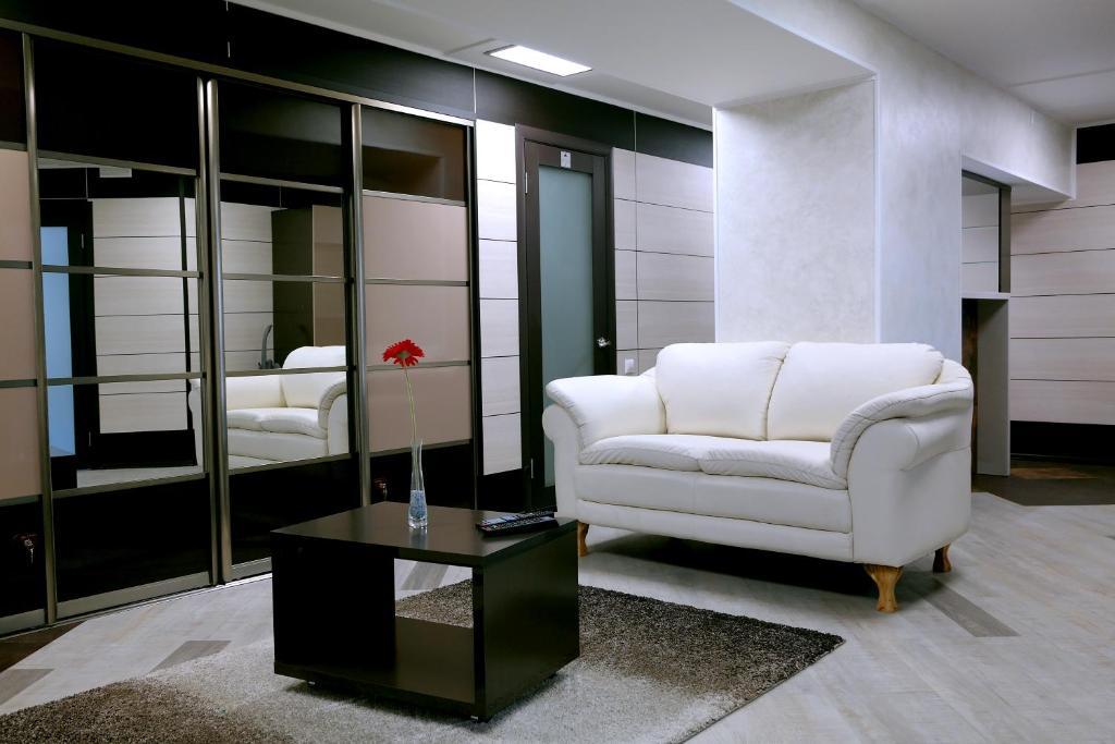 ein Wohnzimmer mit einem weißen Stuhl und einem Tisch in der Unterkunft Apartments DAF-Center in Oral