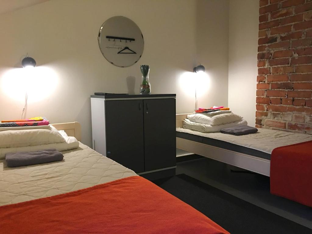 a bedroom with two beds and a mirror on the wall at Hostel Suomenlinna in Helsinki